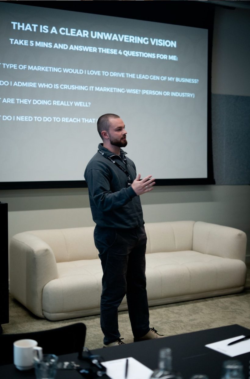 Tiarnan presenting in front of a projector screen